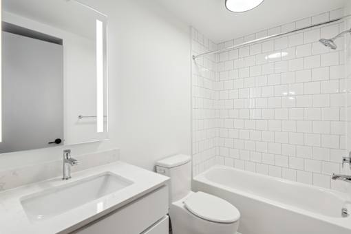 A white bathroom with a sink, toilet, and bathtub.