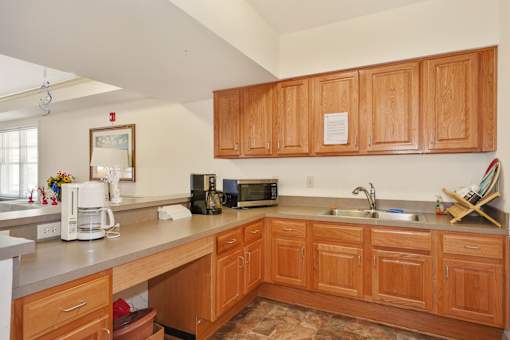 A kitchen with wooden cabinets and a white counter top.