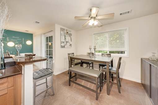 A kitchen with a dining table and chairs.