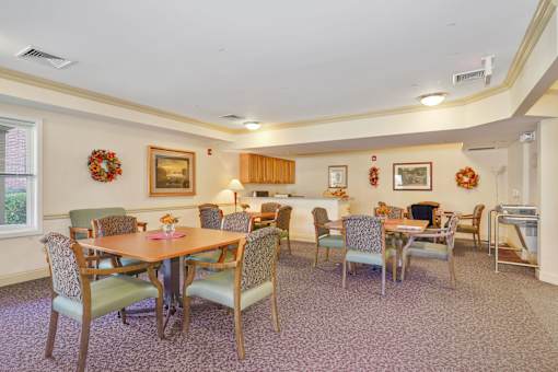 A dining room with a table surrounded by chairs.