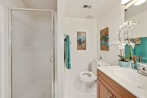 A bathroom with a toilet, sink, and shower.