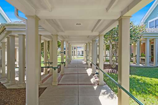 A long white covered walkway with columns on either side.