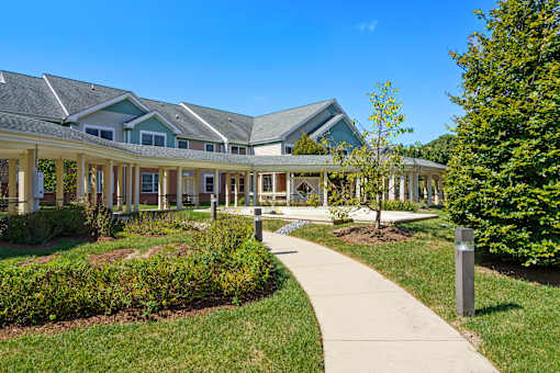 A building with a green roof and a walkway in front of it.