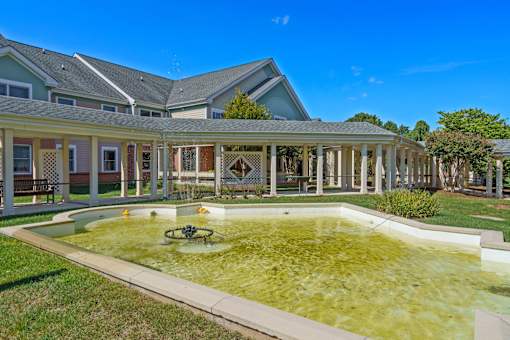 A pool with a fountain in the middle of it.