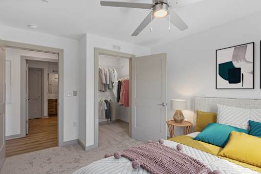 A bedroom with a bed, a ceiling fan, and a wardrobe.