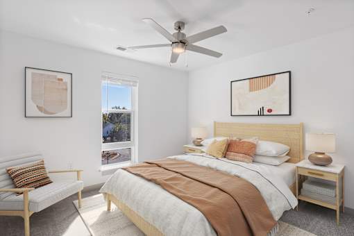 A bedroom with a large bed and a ceiling fan.