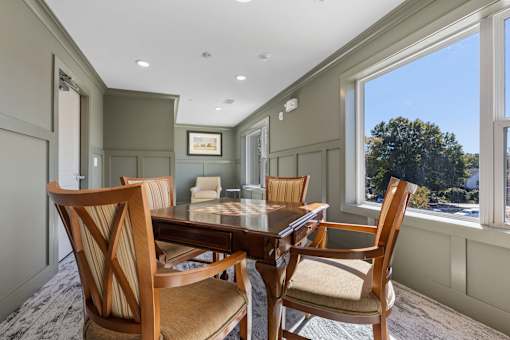 A dining room with a wooden table and chairs.