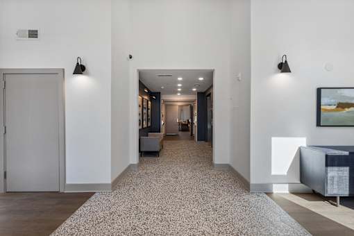 A hallway with a carpeted floor and a painting on the wall.