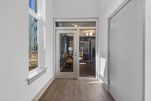 A modern interior with a glass door leading to a living area.