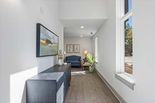 A long hallway with a blue couch and a painting on the wall.