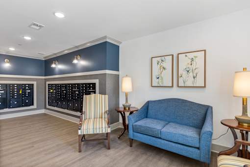 A blue couch sits in a room with a chair and two lamps.