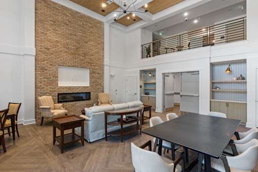 A modern living room with a brick wall and a fireplace.