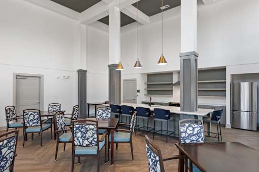 A dining room with a table surrounded by chairs.