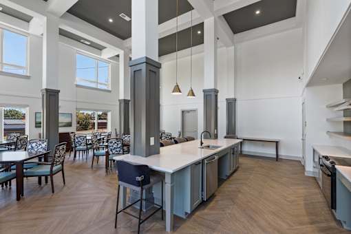 A modern kitchen with a long island and chairs.