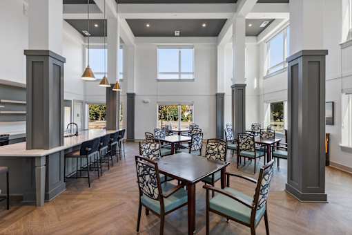 A large dining room with a long table surrounded by chairs.