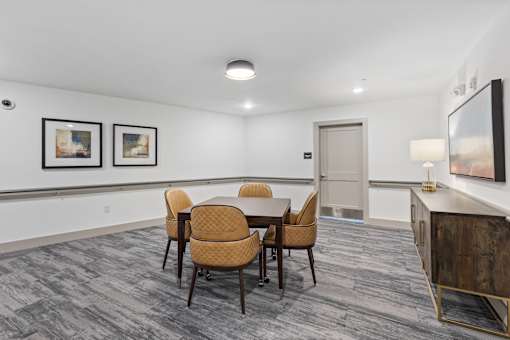 A conference room with a table, chairs, and pictures on the wall.