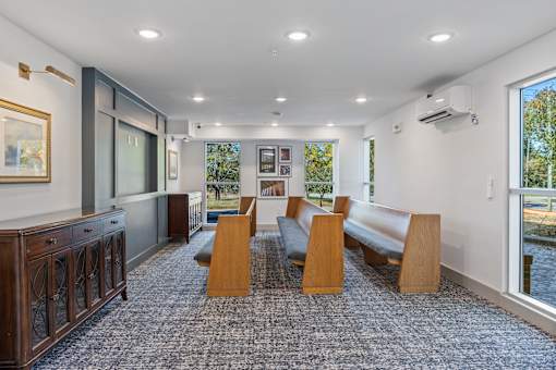 A room with a carpeted floor and wooden furniture.