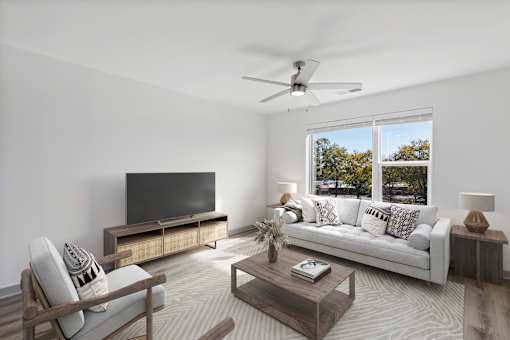 A modern living room with a television, sofa, and a wooden coffee table.