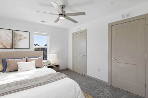 A bedroom with a large bed and a ceiling fan.