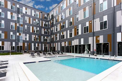 A large indoor swimming pool in front of a multi-story building.