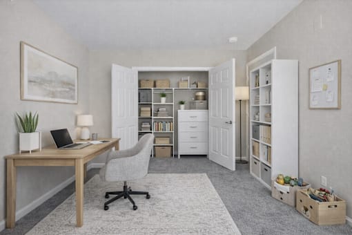 A room with a desk, chair, and a potted plant.