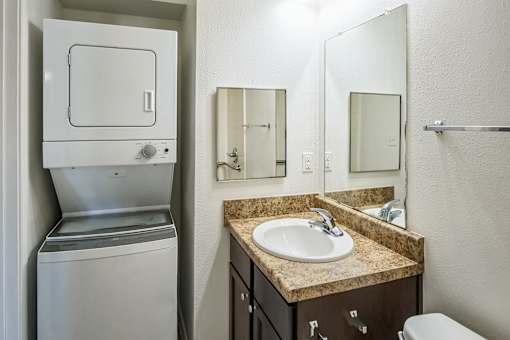 A bathroom with a sink, mirror, and toilet.