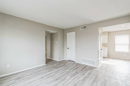 A room with a white door and a window with blinds.