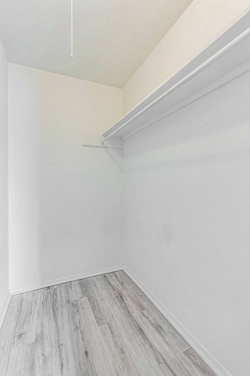 A room with a white wall and a grey floor.