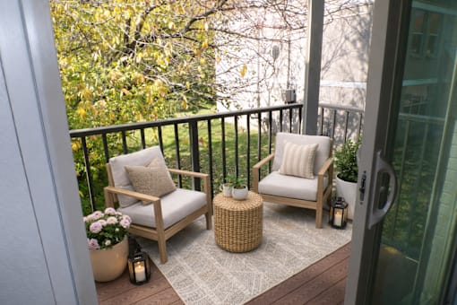A balcony with two chairs and a table.