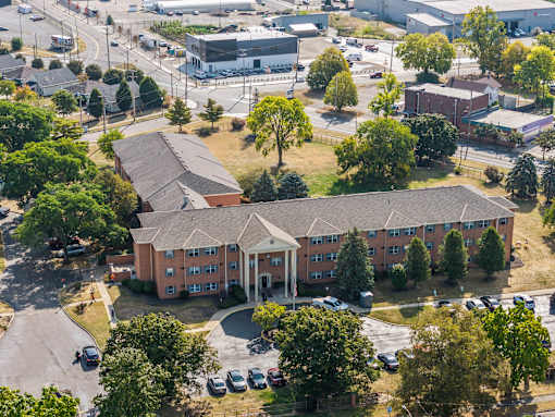 A large apartment complex with a parking lot in front.