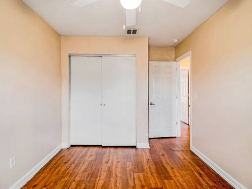 A room with a white door and a white closet.