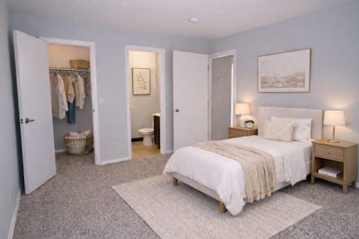 A bedroom with a bed, nightstands, and a closet.