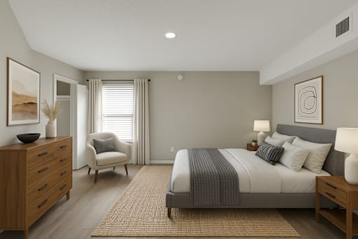 A bedroom with a large bed, a chair, and a dresser.