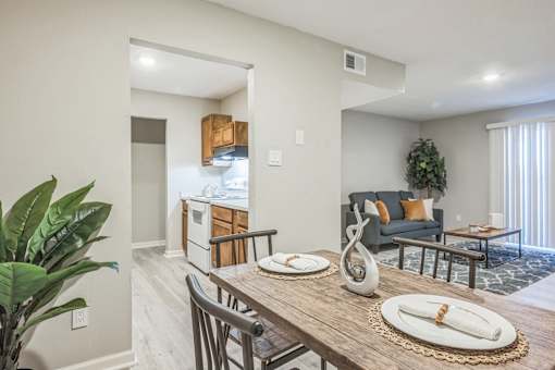 A dining room with a wooden table set for two.