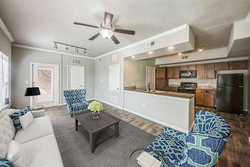 A living room with a white couch, a coffee table, and a ceiling fan.