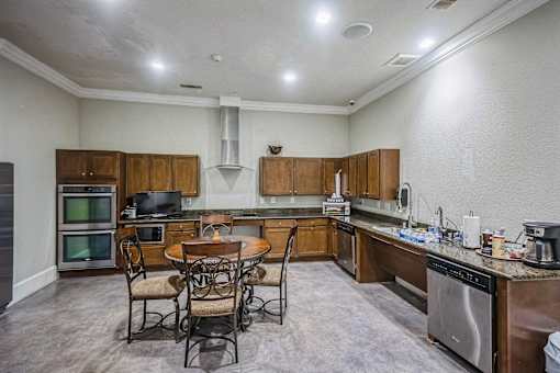 A kitchen with a table and chairs in the middle of the room.