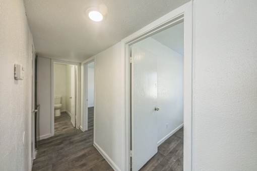 A hallway with a white door and a light on the ceiling.