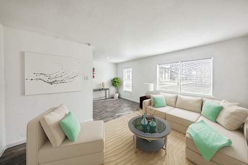 A living room with a beige couch, a glass coffee table, and a painting on the wall.