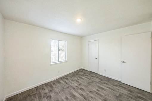 A room with a window and two doors.