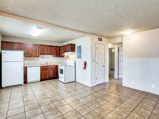 A kitchen with white appliances and brown cabinets.