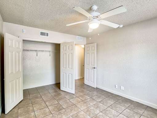 A room with a ceiling fan and tiled flooring.