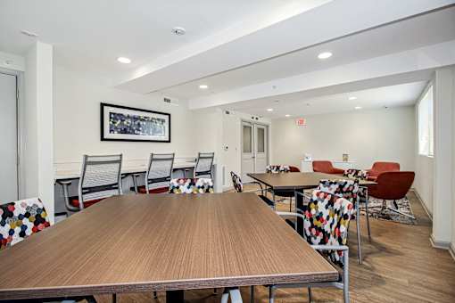 a communal dining room with tables and chairs at the addison apartments