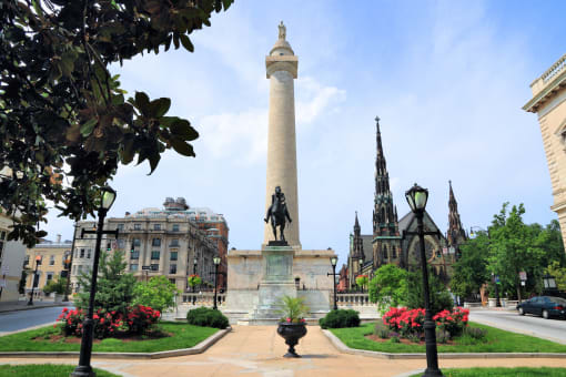 a tall column with a statue in the middle of a city street