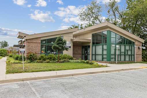 the front of a building with a sidewalk and grass