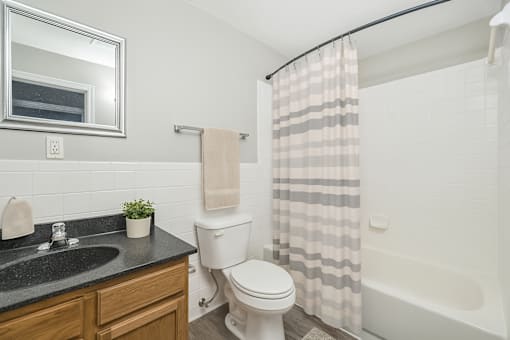 A bathroom with a toilet, sink, and shower.