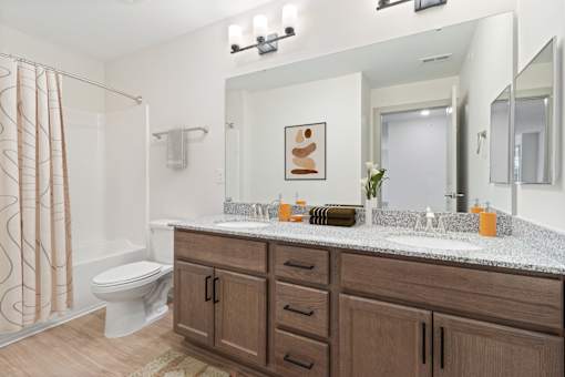 A bathroom with a toilet, sink, and shower.