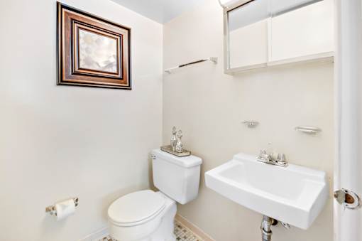 A white toilet and sink in a bathroom.