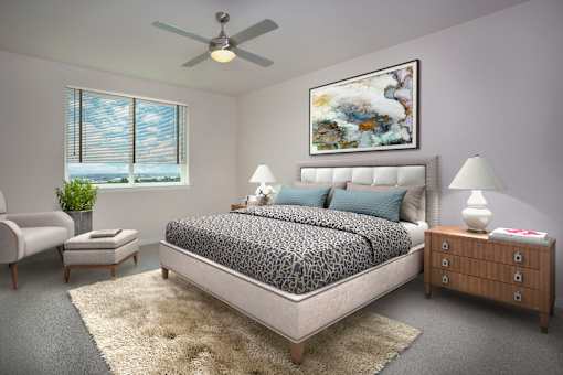 A bedroom with a large bed, a ceiling fan, and a painting on the wall.