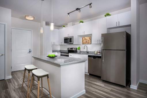 A kitchen with a white island and stools.