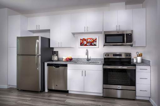 A modern kitchen with stainless steel appliances and white cabinets.